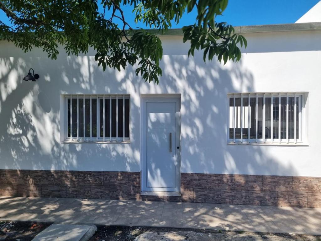 a white building with a door and two windows at Curuzú Confort in Curuzú Cuatiá