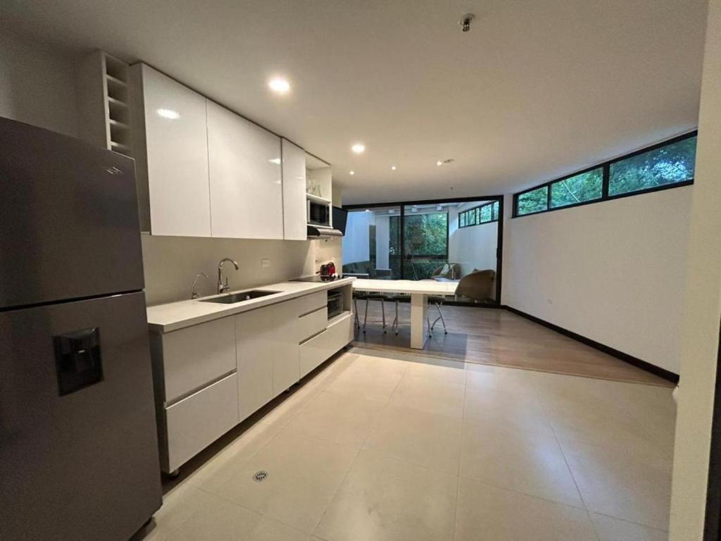 a kitchen with white cabinets and a large window at Room in BB - Suite Presidencial en hotel proximo al aeropuerto in San Antonio de Pereira