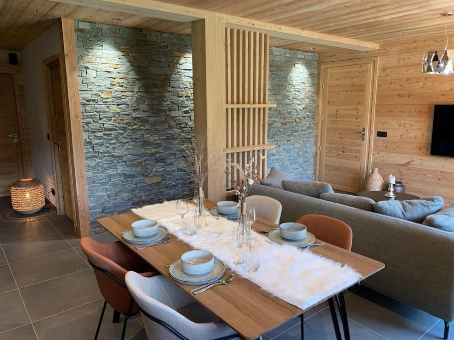 a dining room with a table and a couch at Superbe chalet avec vue montagne in Orcières