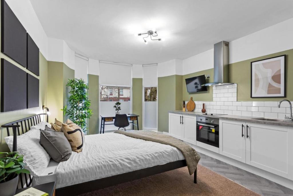 a bedroom with a bed and a kitchen at Birkenhead Aparthotel in Rock Ferry