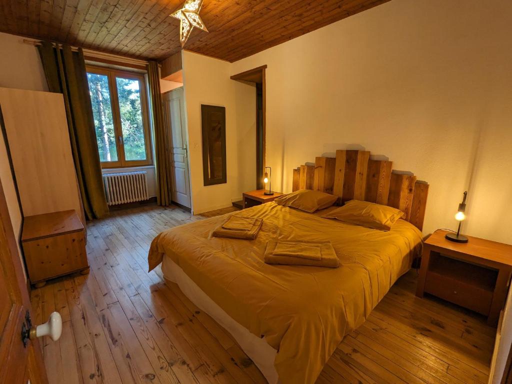 1 dormitorio con 1 cama grande y 2 toallas. en Gîte Le Chambon-sur-Lignon, 9 pièces, 15 personnes - FR-1-582-21, en Le Chambon-sur-Lignon