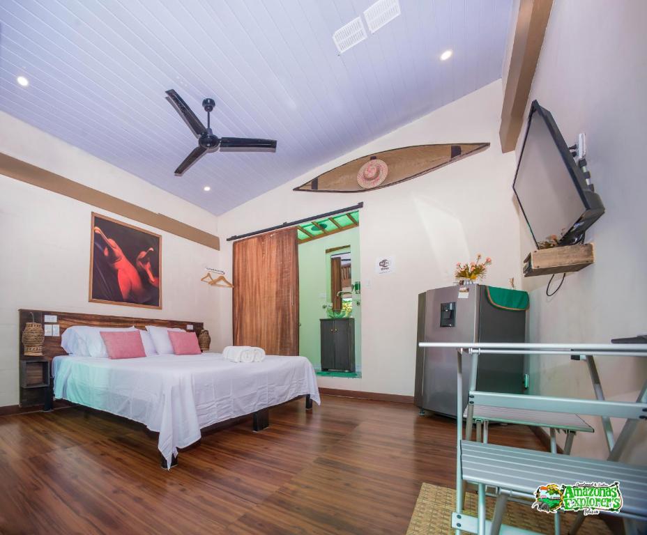 - une chambre avec un lit et une planche de surf sur le mur dans l'établissement AMAZONAS EXPLORERS LETICIA, à Leticia