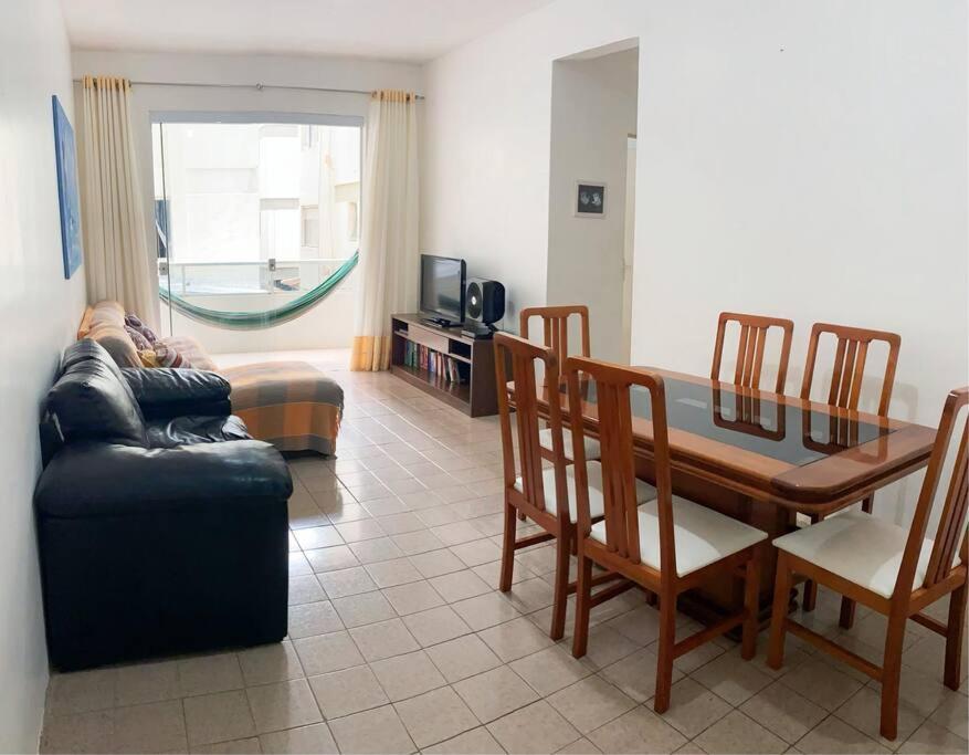 uma sala de estar com um sofá e uma mesa de jantar em Ap férias - 2 qt - Wi-Fi - Guarapari - Praia do Morro em Guarapari