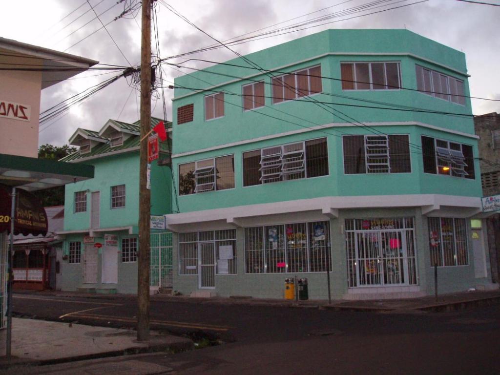 a green building on the corner of a street at Aaron's House in Castries