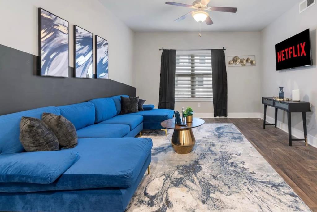 uma sala de estar com um sofá azul e uma mesa em Bliss Peaceful Space em Atlanta