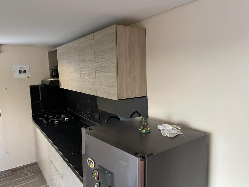 a kitchen with a stainless steel refrigerator and wooden cabinets at Hermoso apartamento en Guatape Antioquia in Guatapé