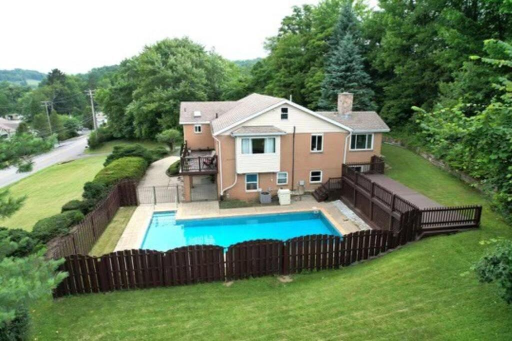 a house with a fence around a swimming pool at Modern and Accessible 5 Bedroom Home in Wexford/Pittsburgh with Private Pool in Wexford