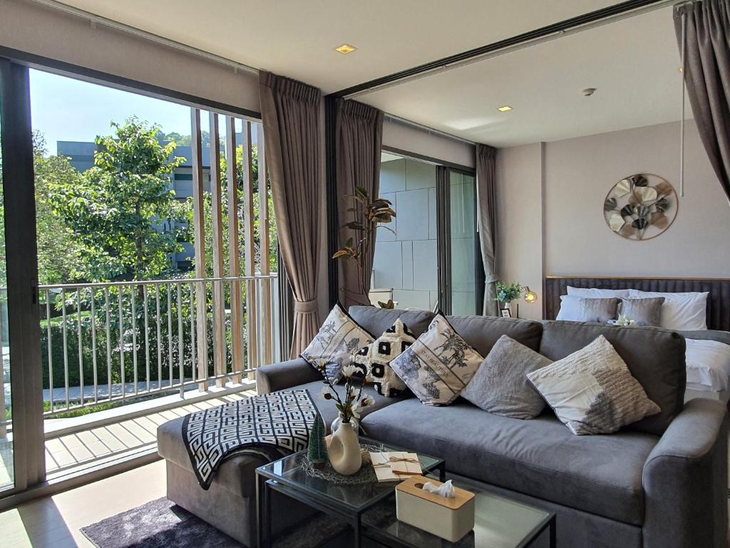 a living room with a couch and a large window at Relaxing 2 Bedroom in Khaoyai in Ban Huai Sok Noi