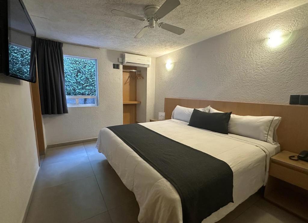 a bedroom with a large bed with a ceiling fan at Hotel Emperador centro Guadalajara y Remodelado in Guadalajara