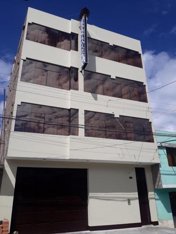 un edificio blanco con muchas ventanas en Hospedaje La Perla Jauja, en Jauja