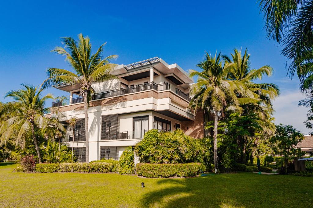 a large house with palm trees in front of it at 3BR Casa Azul - Beachfront Home in Laguna & Layan Chom Tawan and Maan Tawan Residences in Phuket Town