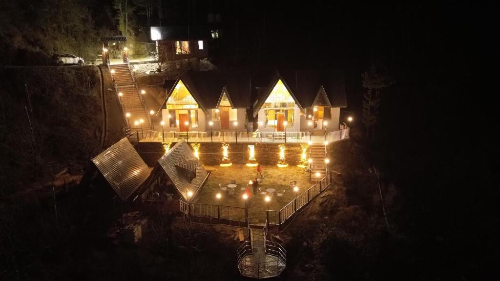 uma vista superior de uma casa com luzes acesas em Snowind Cottages em Kūfrī