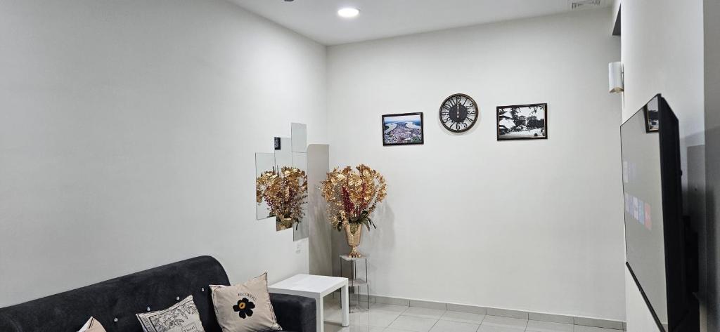 um quarto branco com um sofá e algumas fotos na parede em Teluk Intan Homestay Landed 3BR2B em Teluk Intan