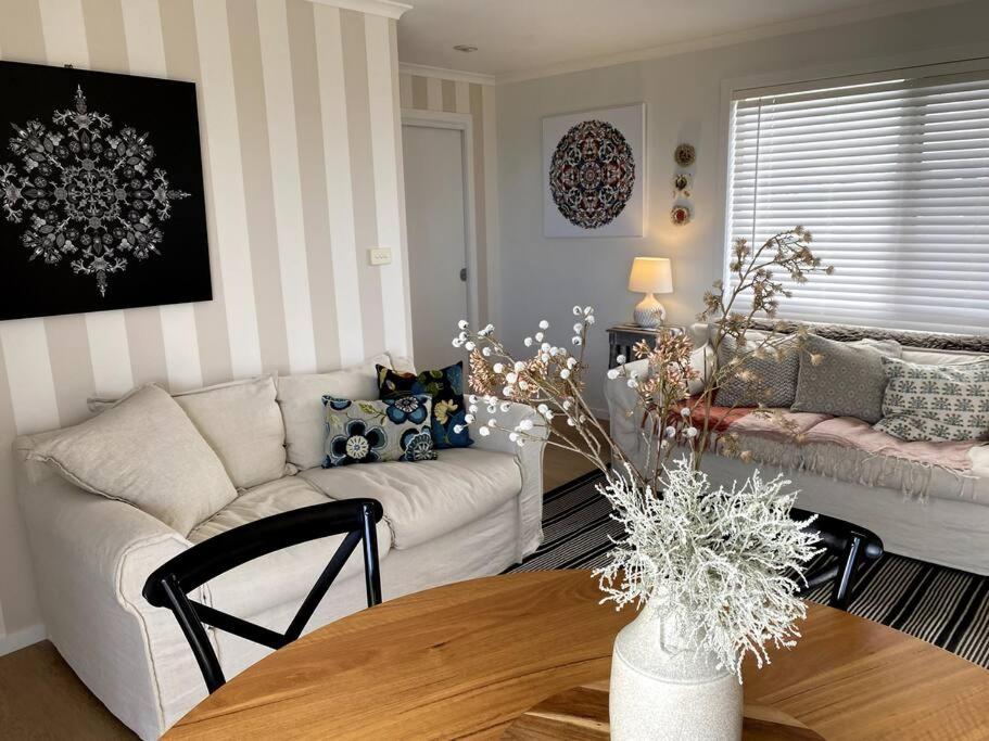 uma sala de estar com um sofá branco e uma mesa em Mima's Nest - Beach House em Lulworth