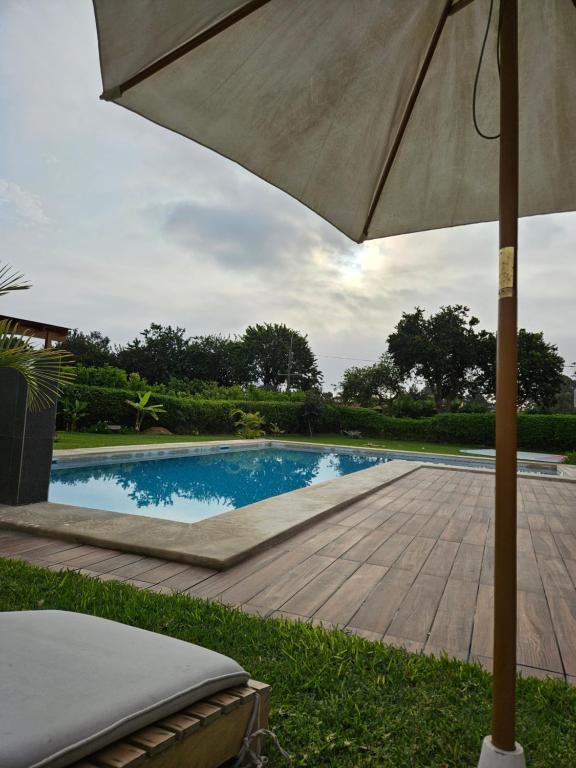 una sombrilla sentada junto a una piscina en Casa de campo Oasis De San Andres, en Miraflores