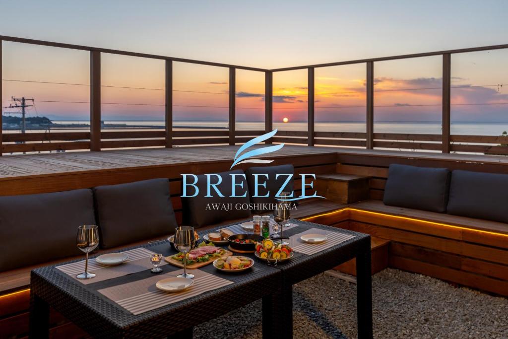 a restaurant with a table with food and wine glasses at BREEZE AWAJI GOSHIKIHAMA in Tusi