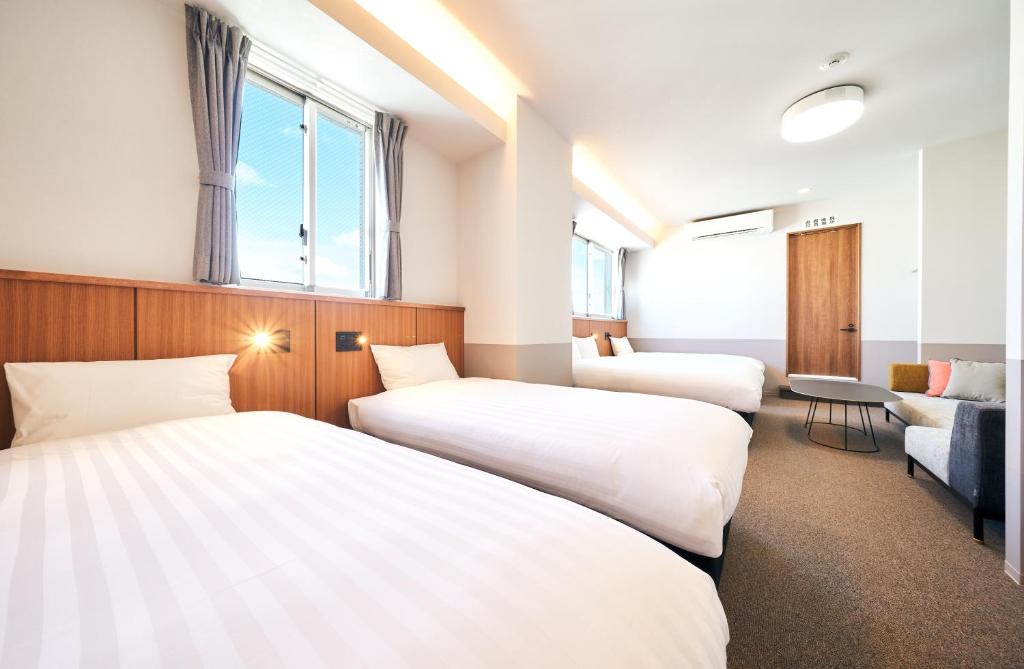 a hotel room with two beds and a couch at Rakuten STAY Naha Yachimun Street in Naha