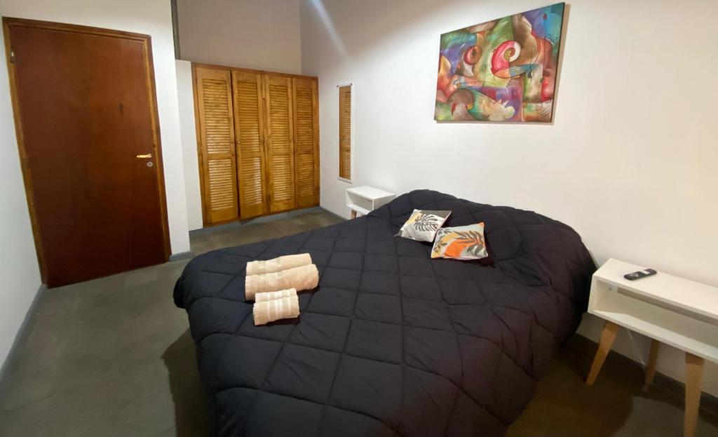 a bedroom with a large black bed and a desk at DYCS DEPARTAMENTOS in San Rafael
