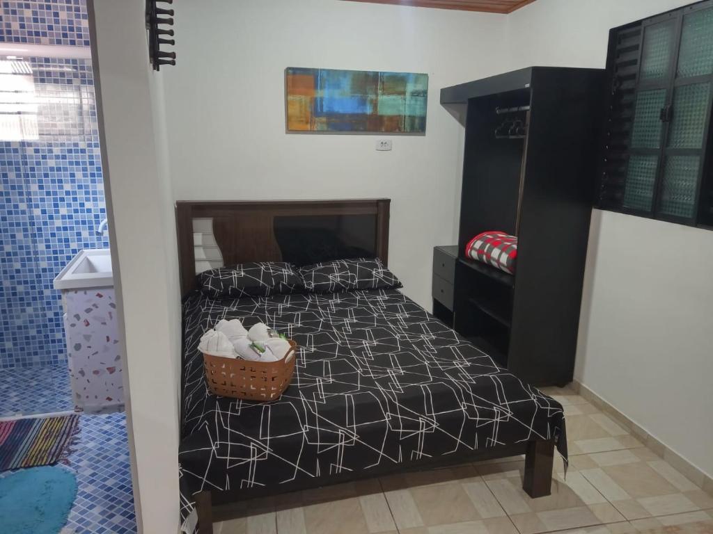 um quarto com uma cama com um cesto em Cantinho da Saudade em Campos do Jordão