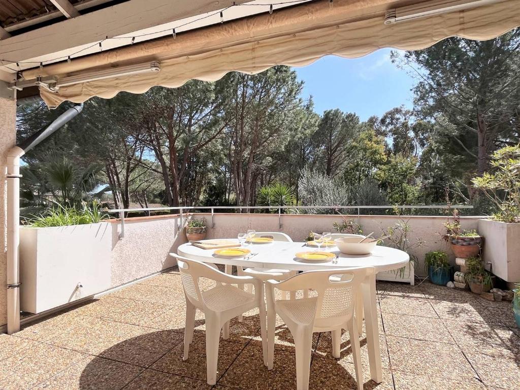 een witte tafel en stoelen op een patio bij Appartement Le Lavandou, 3 pièces, 4 personnes - FR-1-251-529 in Le Lavandou