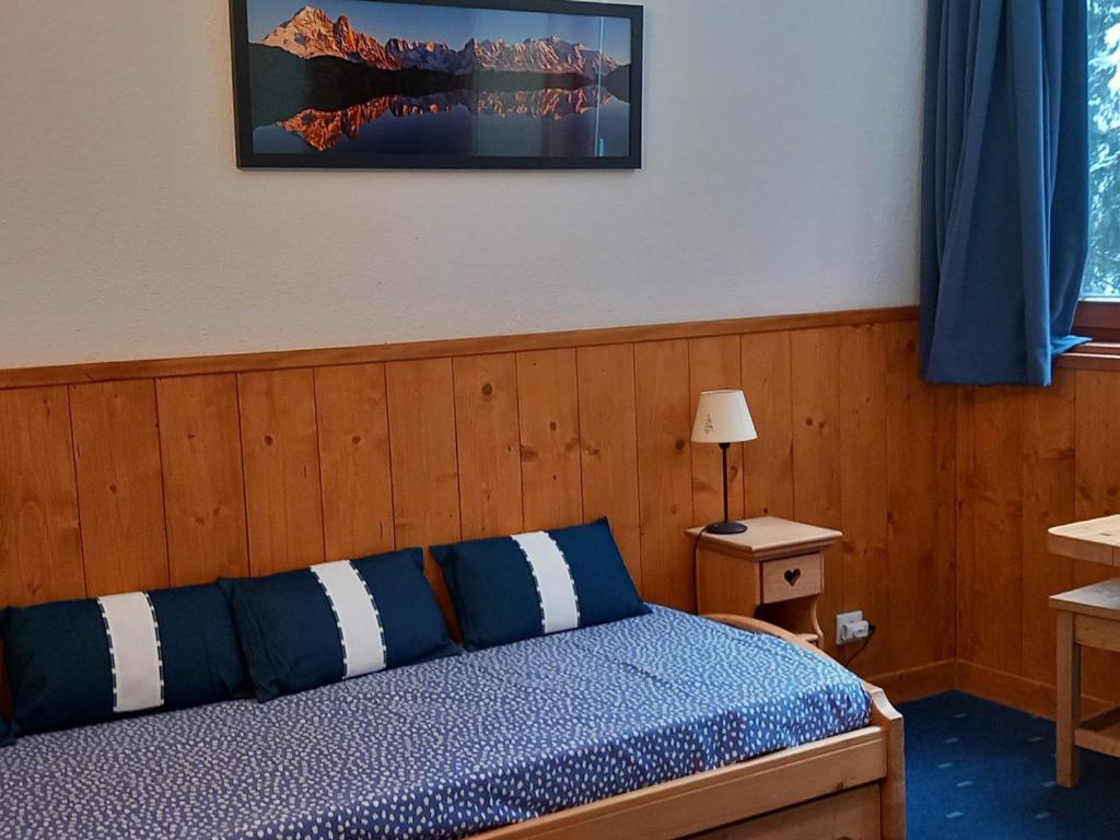 - une chambre avec un lit doté d'oreillers bleus et blancs dans l'établissement Studio Les Arcs 1800, 1 pièce, 2 personnes - FR-1-411-931, à Bourg-Saint-Maurice