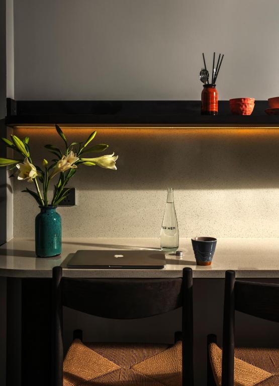A compact dining-work surface with a laptop, bottle and coffee cup.