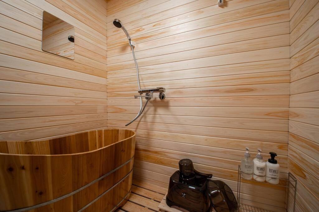 Habitación con bañera de madera y ducha. en Capricious INN kita27jyou en Sapporo