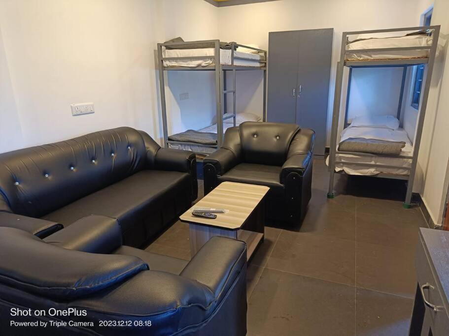 a living room with a couch and bunk beds at Sruthi Garden. Homestay. Kodaikanal in Kodaikānāl