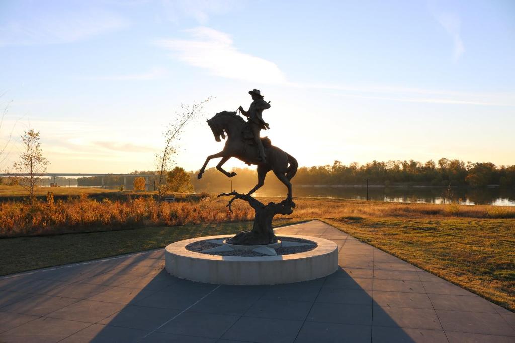 a statue of a man riding a horse on a tree at Old Fort Loft King & Queen suites nearest accomodation to Marshals Museum power your EV for free! in Fort Smith