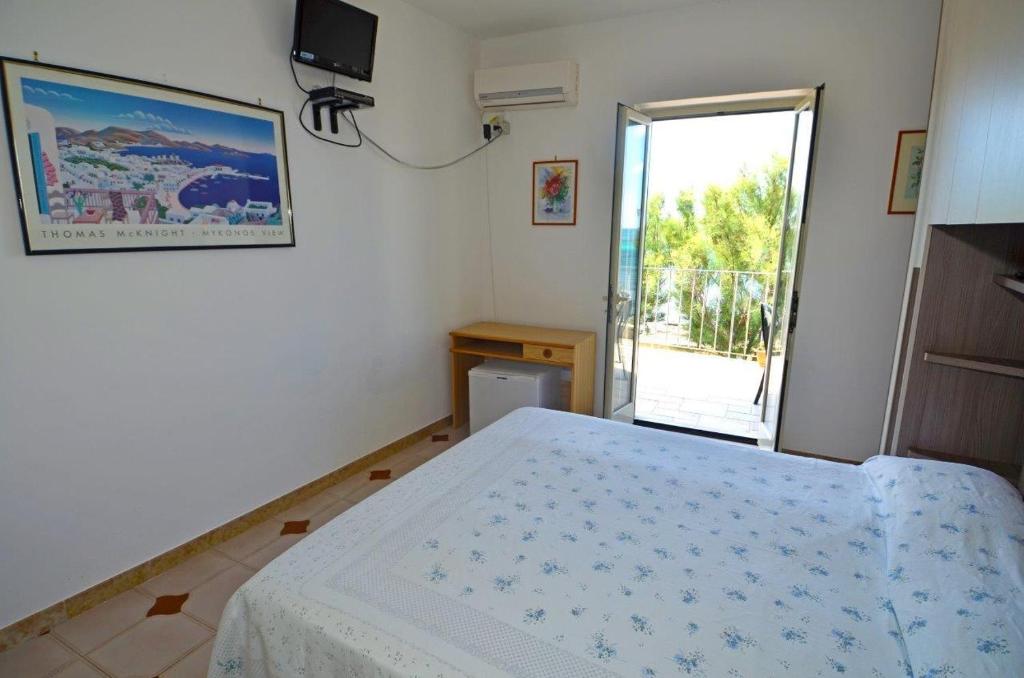 sypialnia z łóżkiem i przesuwnymi szklanymi drzwiami w obiekcie Le sorgenti camere e appartamenti w mieście Torre Vado