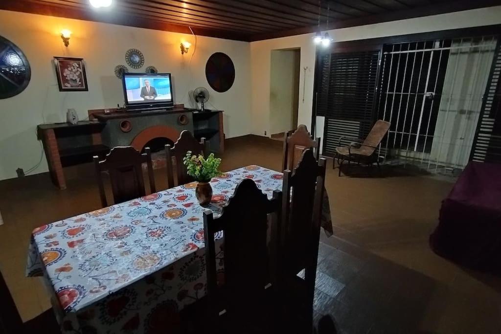a dining room with a table and a television at Moka Refúgium - Uma bela e espaçosa a 200m da praia in Belém