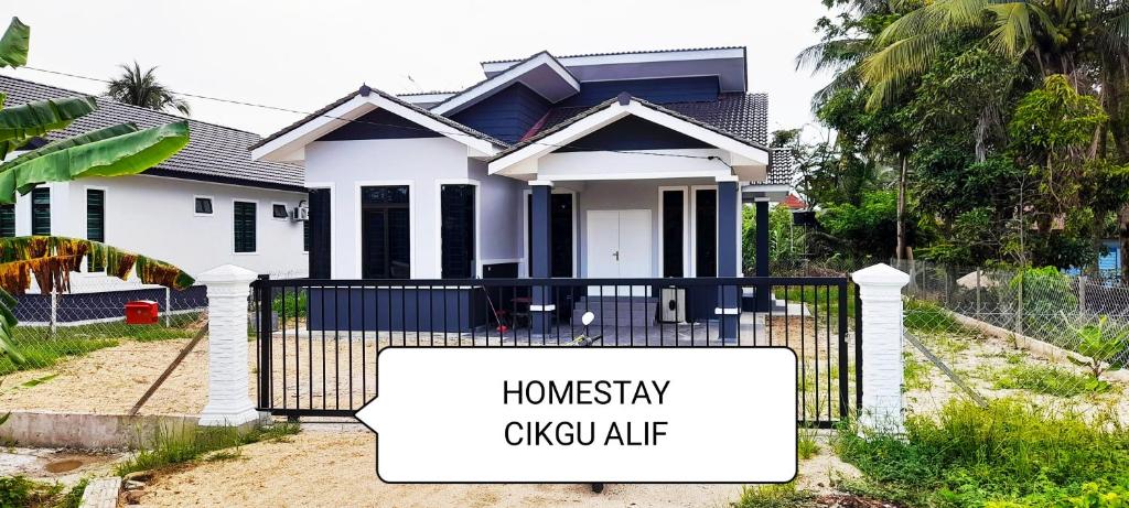 a house with a sign in front of it at Homestay Cikgu Alif in Wakaf Baharu