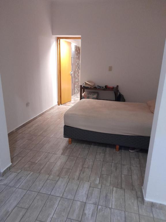 a bedroom with a bed and a wooden floor at Maryhouse in Lomas de Zamora