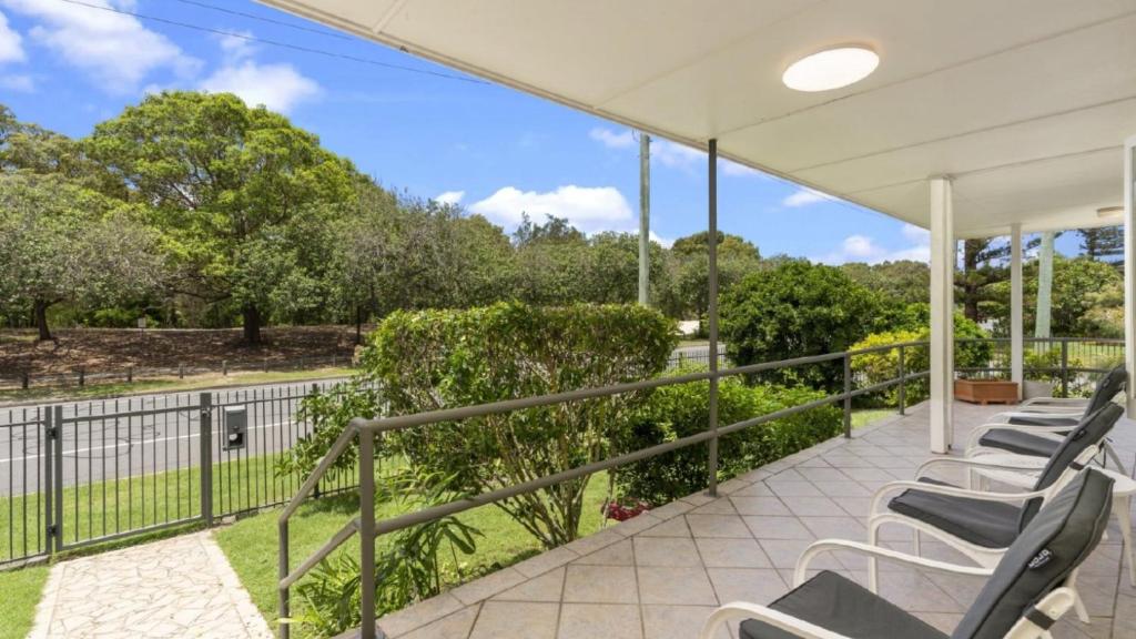 a group of chairs on a balcony with a view of a park at Kooringal Cottage - Home By The Sea in Woorim