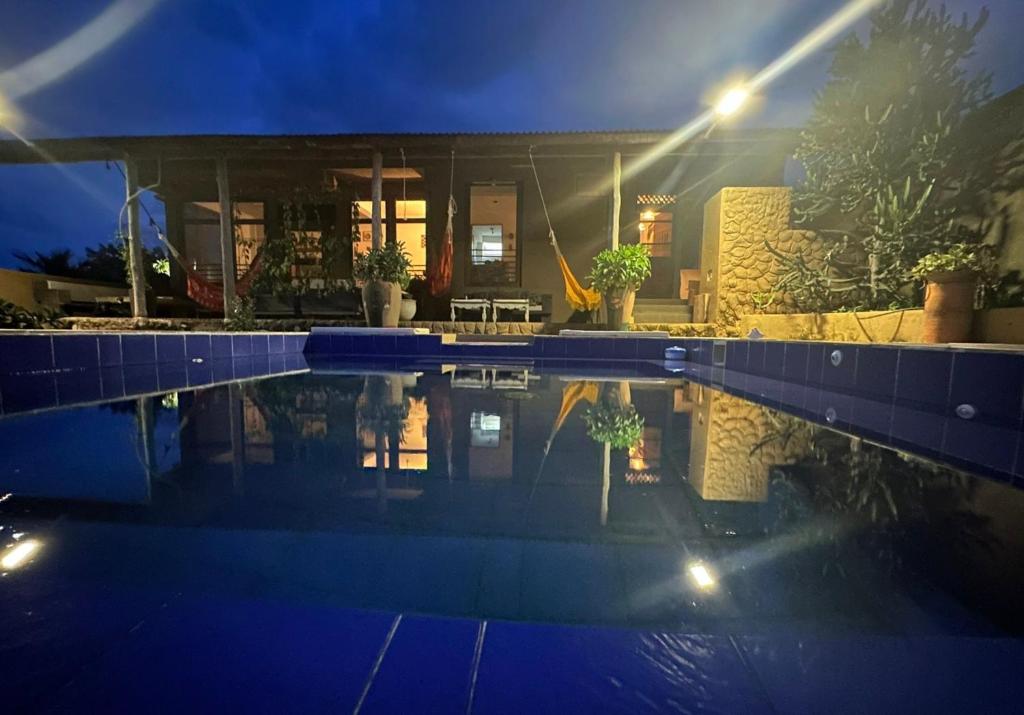 a house with a swimming pool at night at La Candelaria in Dibulla