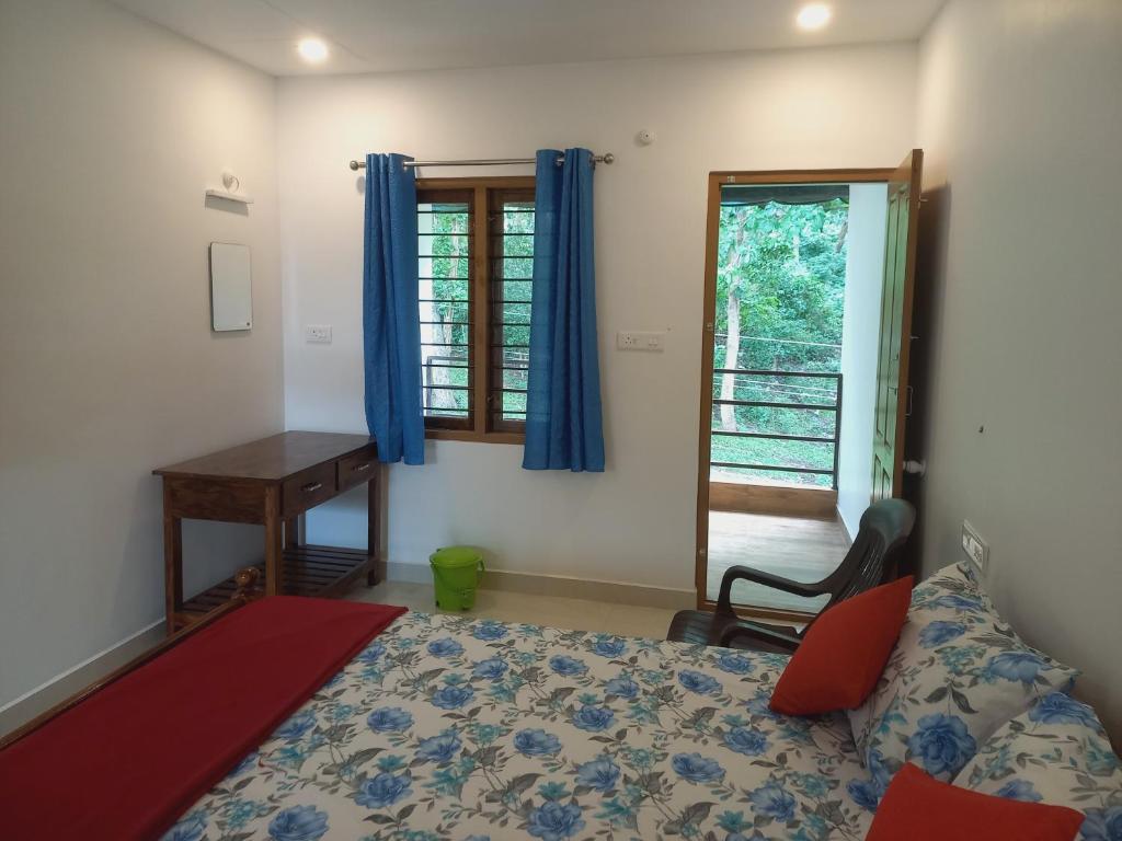 1 dormitorio con cama, escritorio y ventana en Wild Window - Forest View Homestay, en Thekkady