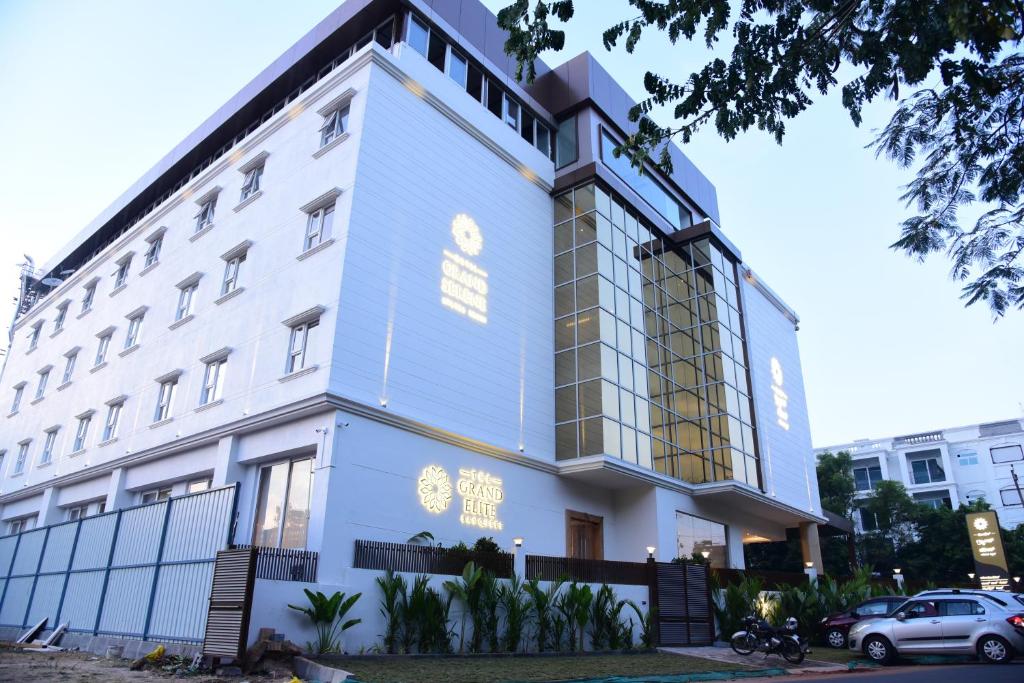 ein weißes Gebäude mit gelben Lichtern in der Unterkunft Hotel Grand Serene, Mysore in Mysore