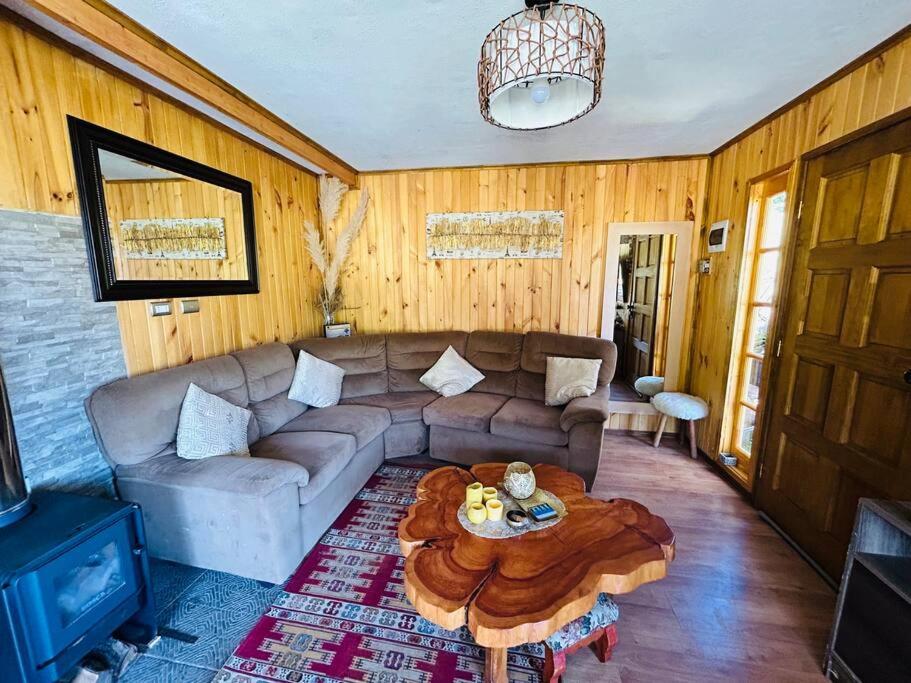 a living room with a couch and a coffee table at Cabaña Puerto Octay in Puerto Octay