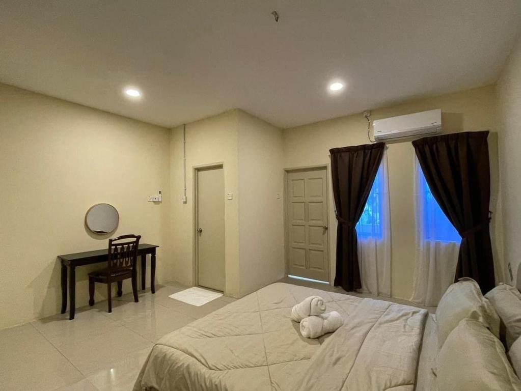 um quarto com uma cama com um bicho de peluche em Four Rooms Homstay 'A' With Wifi And Smart TV in Wakaf Tapai 