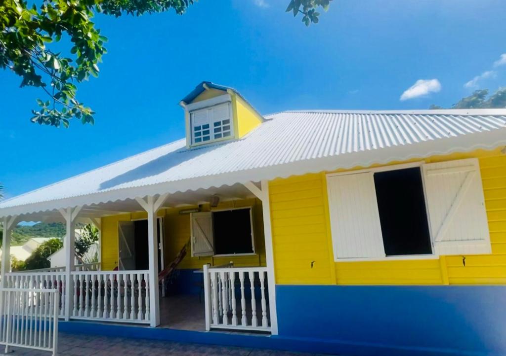 a yellow house with a white roof at Villa Réséda in Sainte-Anne