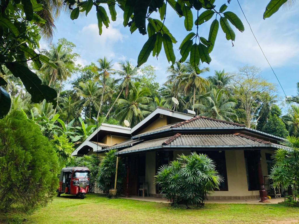a house with a red truck parked in front of it at Green nature villa in Hapugala