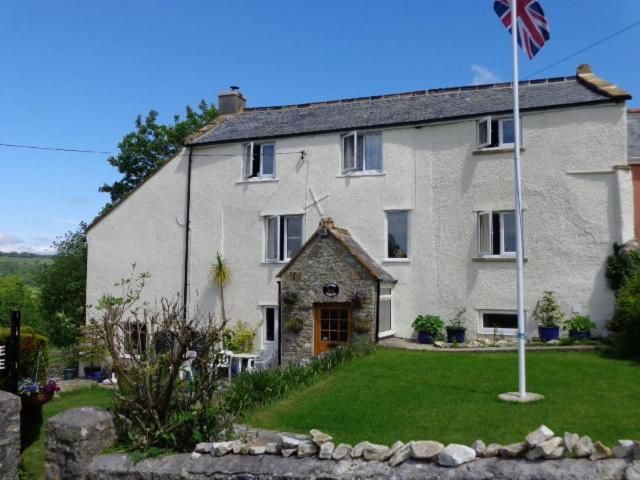 una casa grande con una bandera delante de ella en Lodge House B&B, en Buckland St Mary