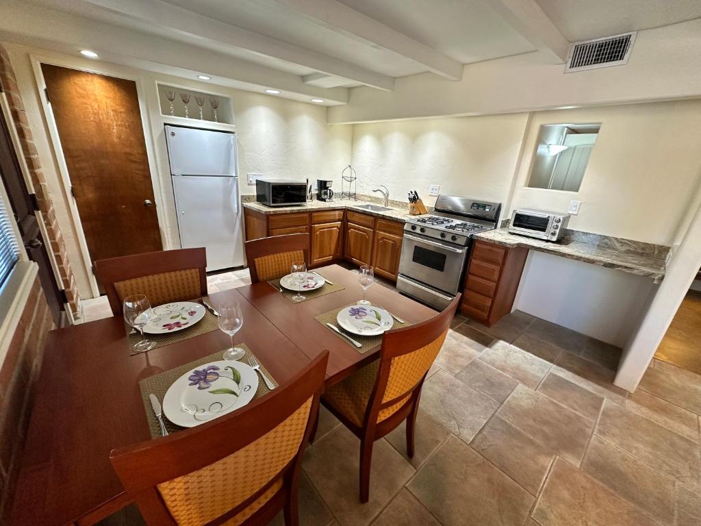 a kitchen with a wooden table and chairs and a kitchen with a table and chairs at One Bedroom Apartment at Rancho Rillito in Tucson