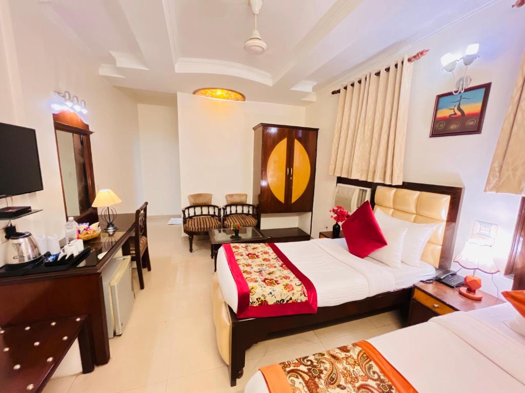 a hotel room with two beds and a desk at Paras Inn in New Delhi