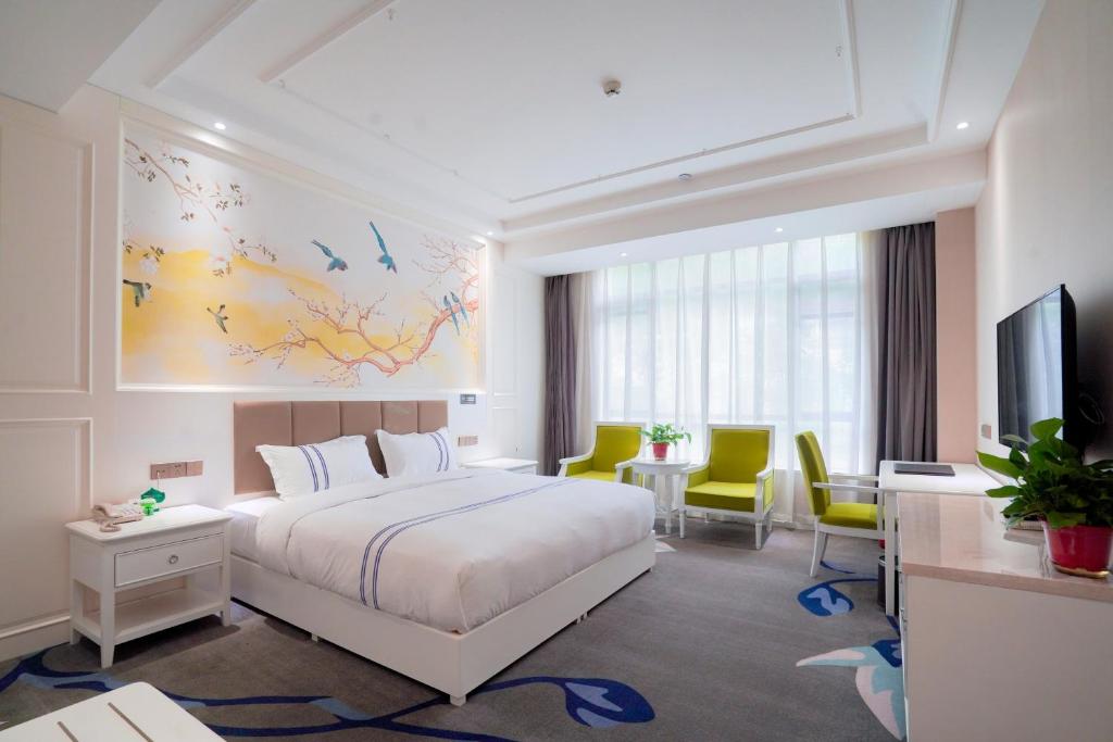 a hotel room with a bed and a tv at Huashan Xinyuan International Hotel in Huayin