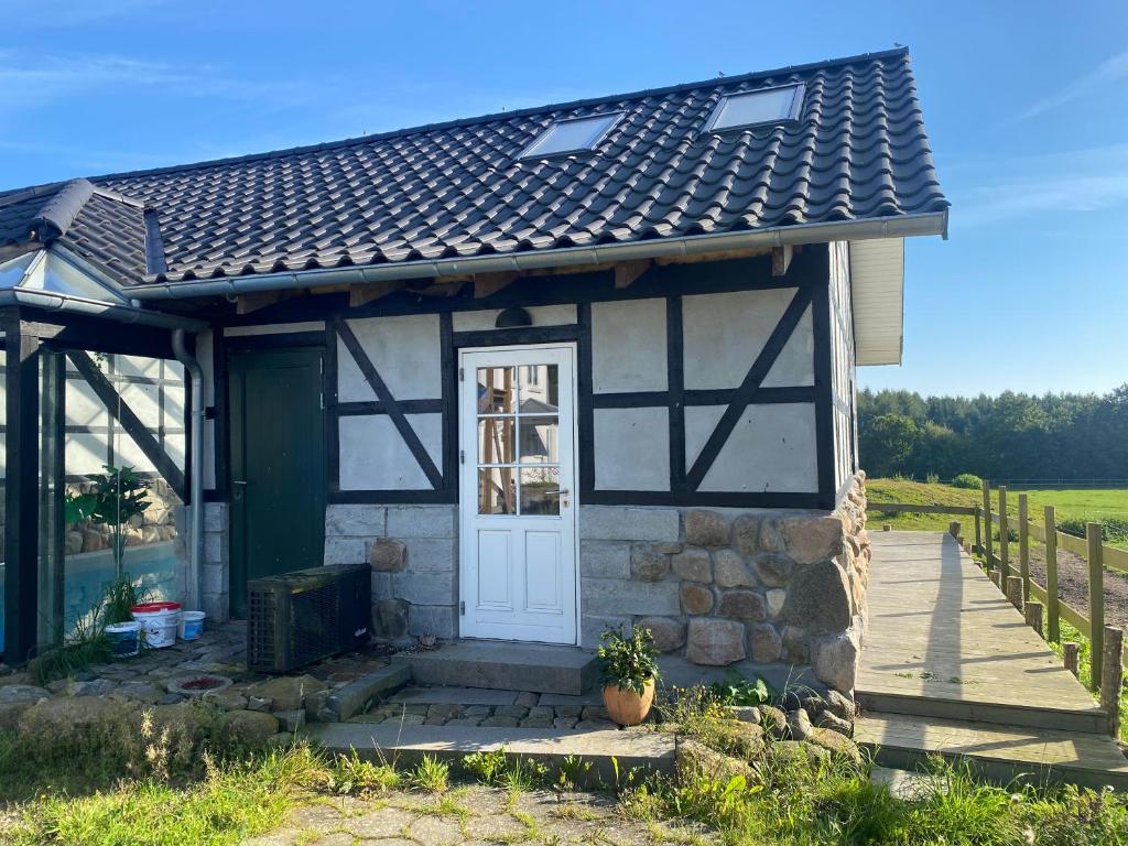 Cabaña pequeña de piedra con puerta blanca en Poolhouse, no smoking everywhere, en Kvistgård