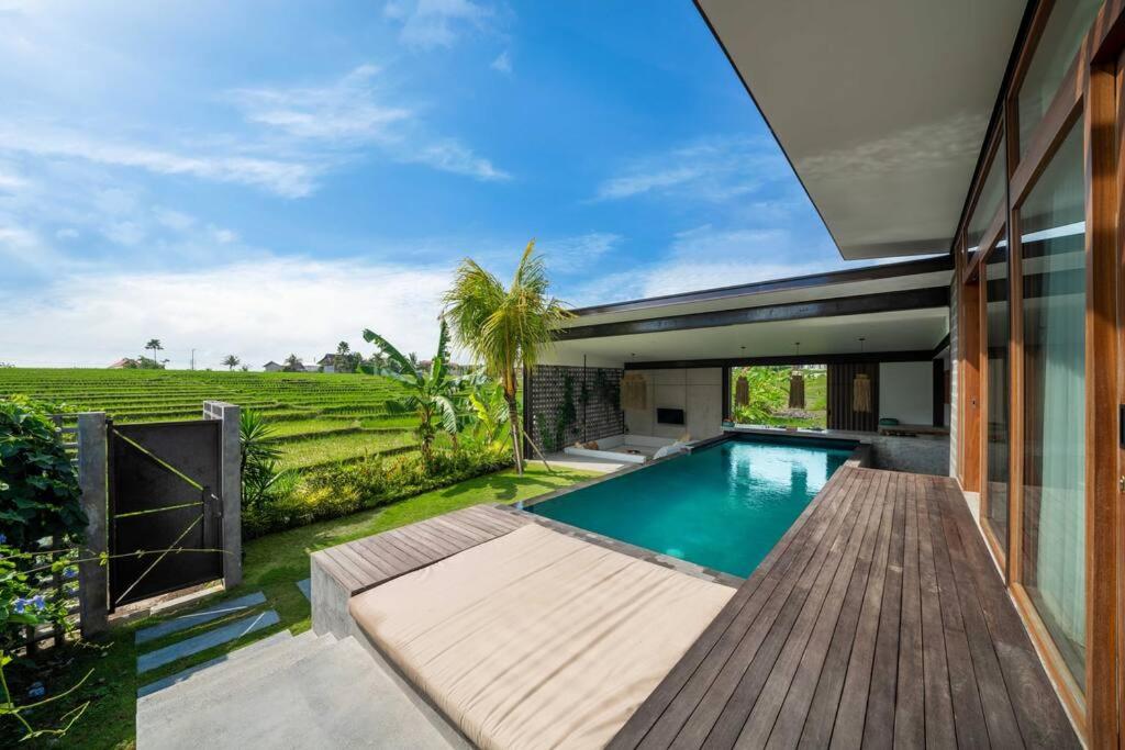 einen Pool im Hinterhof eines Hauses in der Unterkunft Villa Lennon - Tropical 3 Bedroom Villa Facing The Rice fields in Canggu