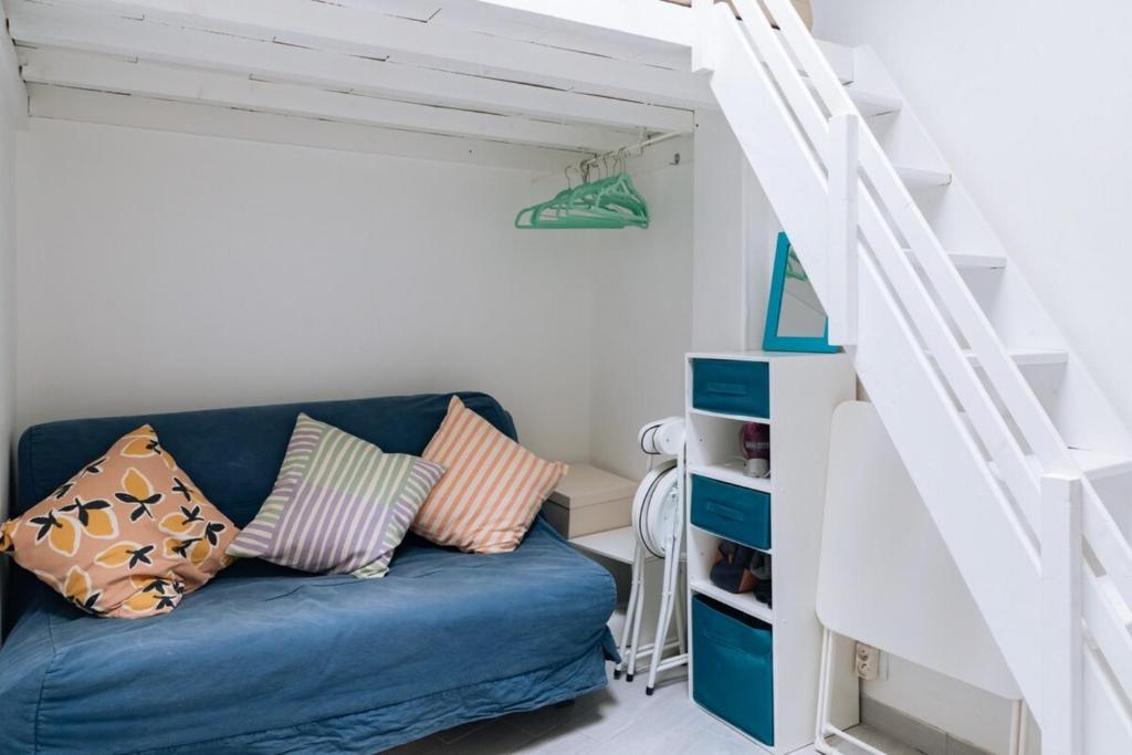 een blauwe bank in een kamer met een trap bij Chic Studio Apartment for 3 - La Villette! in Parijs