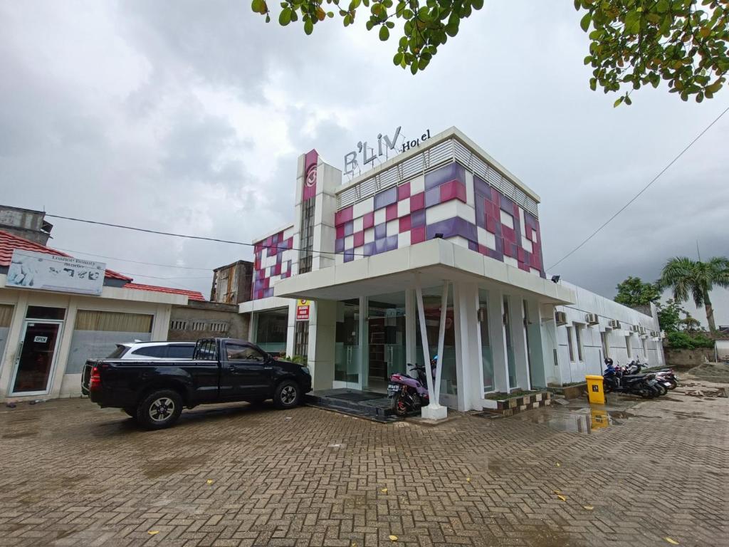 een vrachtwagen geparkeerd voor een gebouw bij Urbanview Hotel B Liv Kendari in Puunggolaka