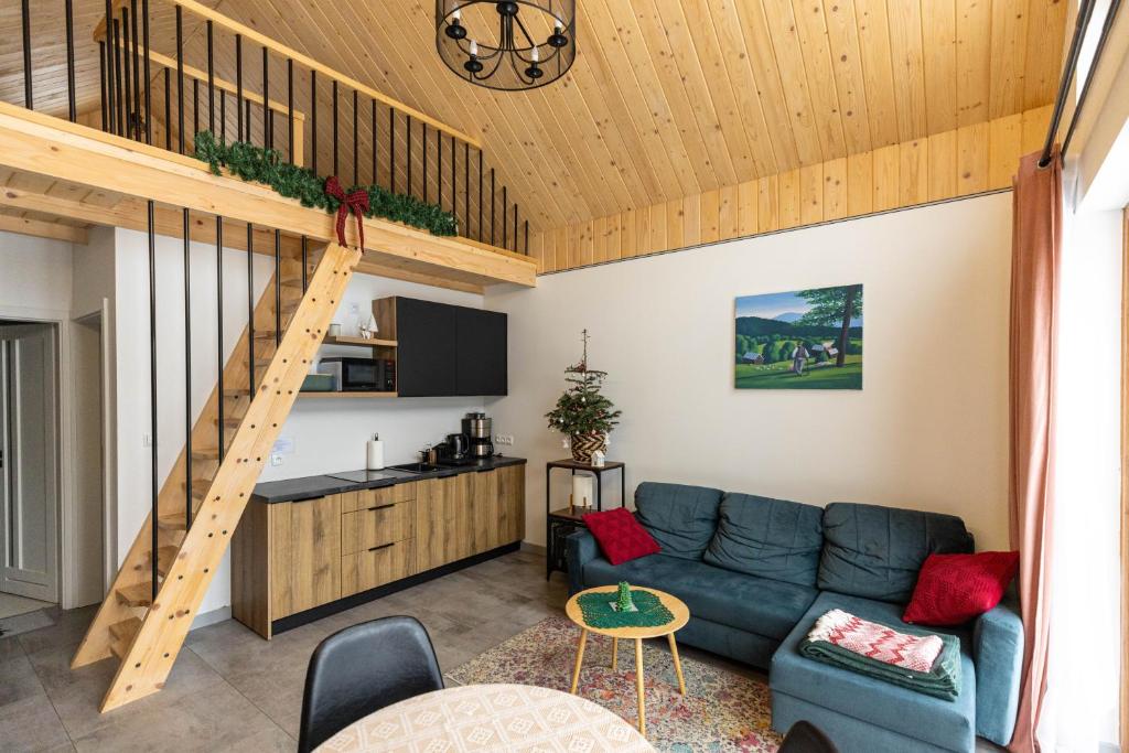 ein Wohnzimmer mit einem Sofa und einer Treppe in der Unterkunft Tiny Domek w Dolinie Popradu, Piwniczna-Zdrój in Piwniczna-Zdrój
